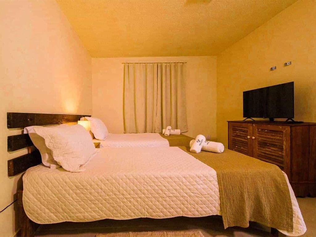Quarto com cama de casal e janelas de madeira