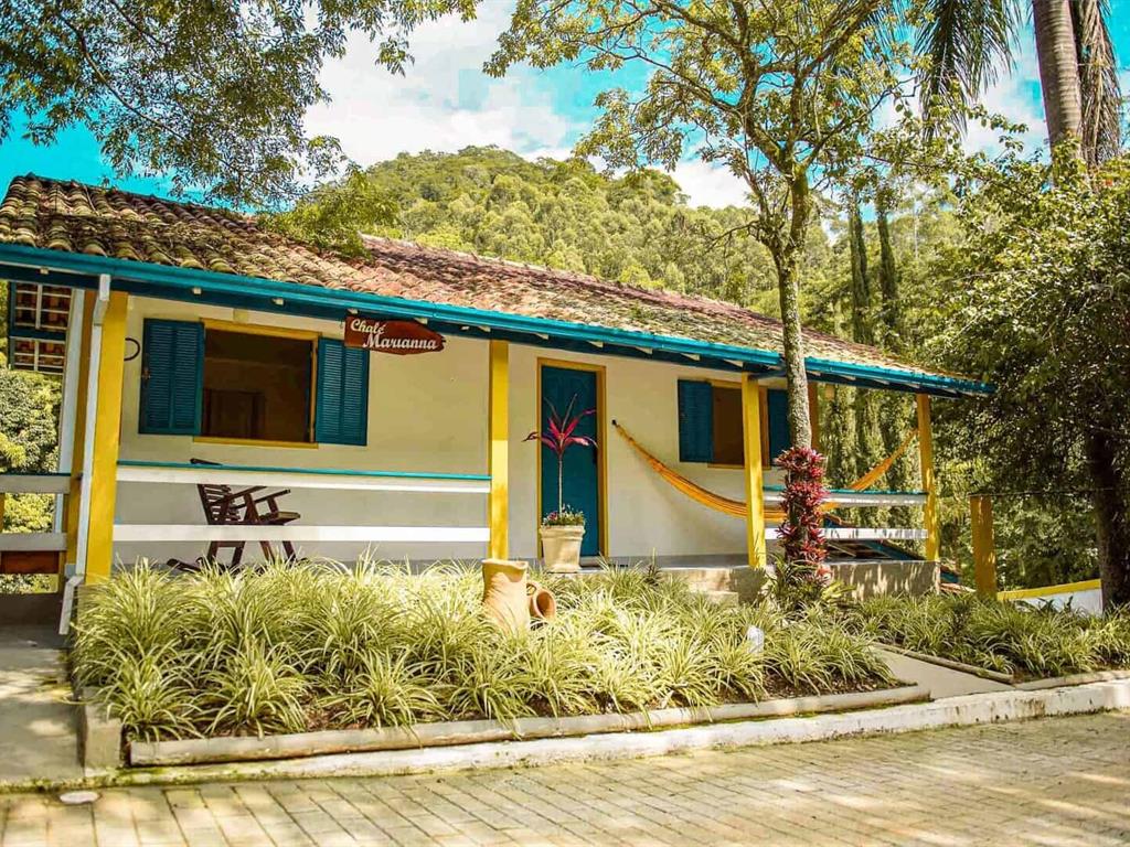 Rede branca em varanda de madeira voltada para o jardim