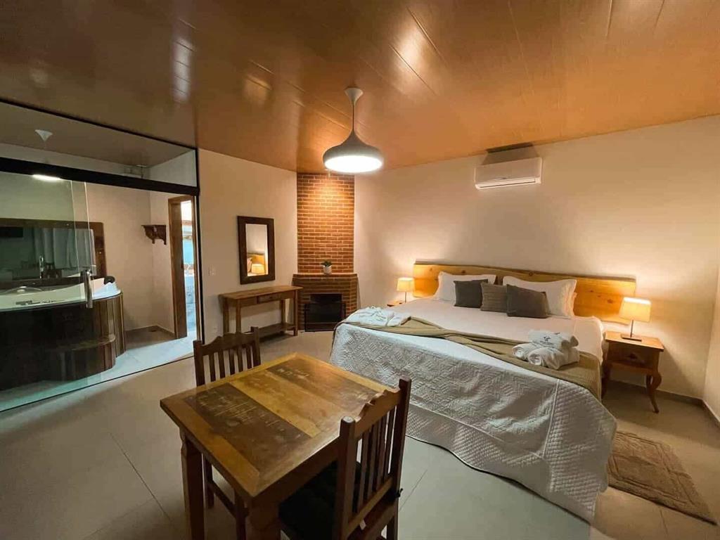 Quarto com cama de casal, poltrona e mesa