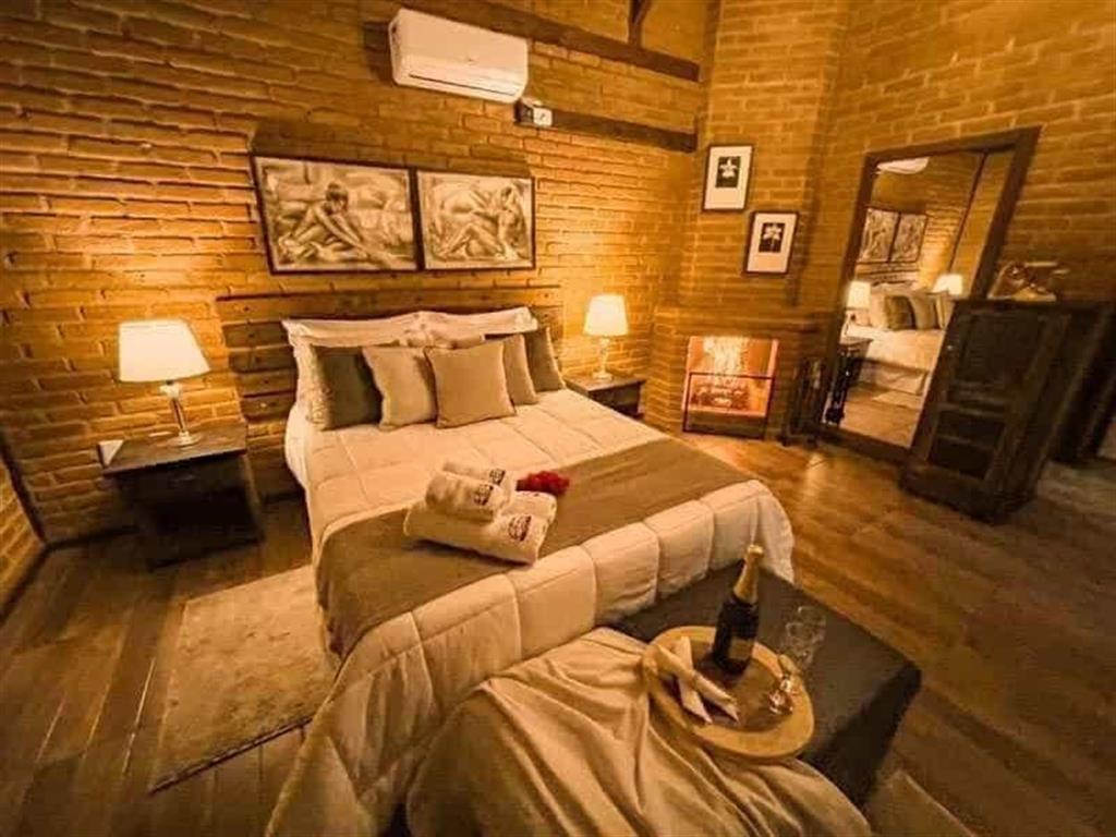 Sala de madeira com sofá, poltronas e lareira