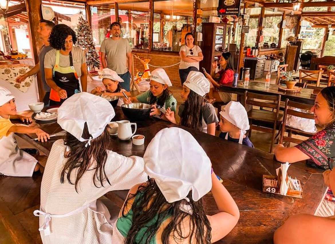 Crianças com chapéus de cozinheiro em atividade no restaurante