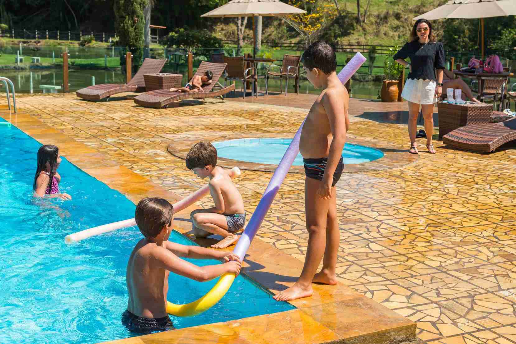Crianças e recreador brincando na piscina